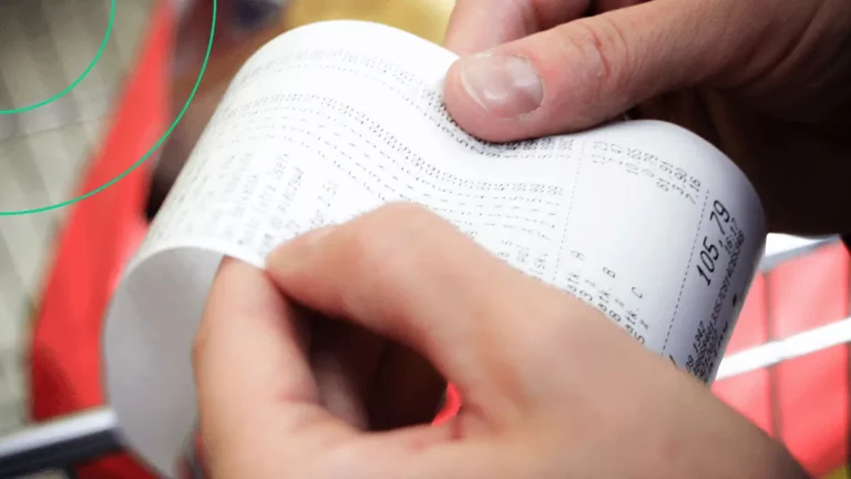 Close-up de uma pessoa conferindo uma NFC-e impressa