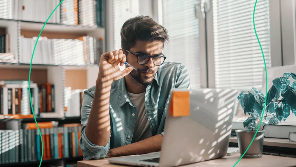 Em seu local de trabalho, empresário olha pensativo para o computador, tentando entender o que é CNAB