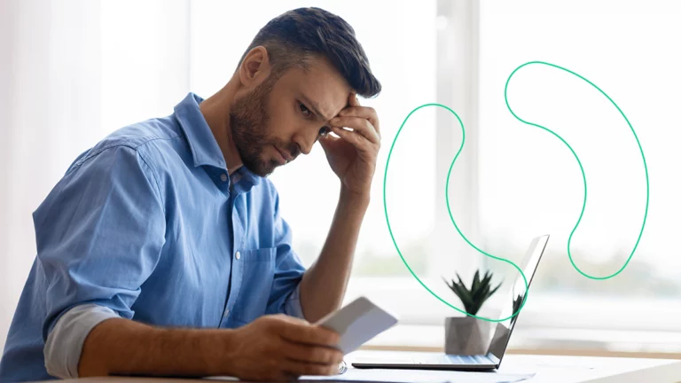 Empresário preocupado, olhando confuso para o celular e para o notebook, tentando entender como cadastrar o código NCM