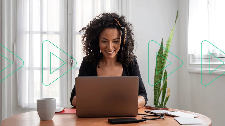 Empresária olhando para o notebook sorrindo, feliz ao saber que o Bling agora emite nota fiscal de serviços para Curitiba