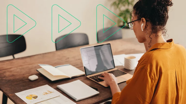 Mulher com diversos relatórios em sua mesa, analisando os problemas do seu fluxo de caixa no laptop