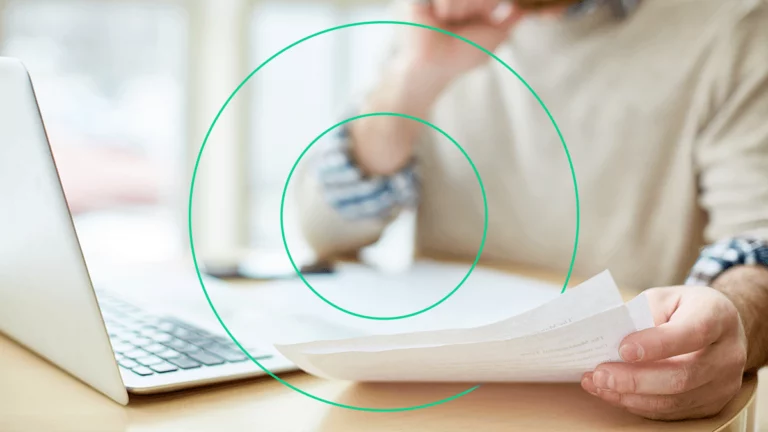 Empreendedor analisando documentos fiscais em sua mesa, se preparando para fazer a manifestação do destinatário