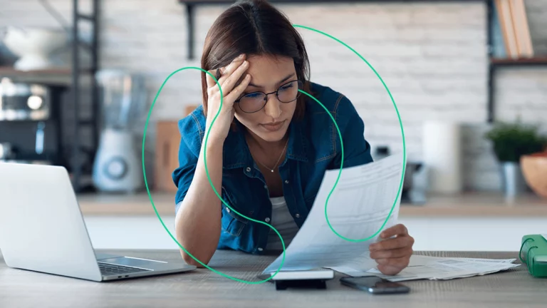 Empresária preocupada e com expressão de estresse olhando para documentos em sua mesa, sem saber o que é DANFe.