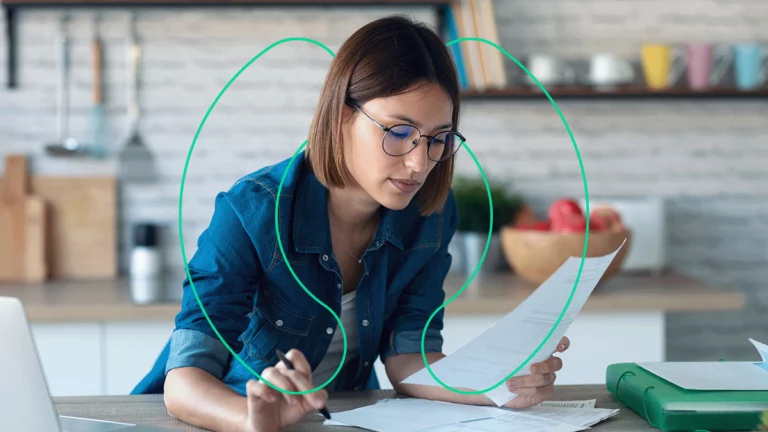 Empreendedora concentrada, conferindo documentos para tentar entender o custo de aquisição dos clientes
