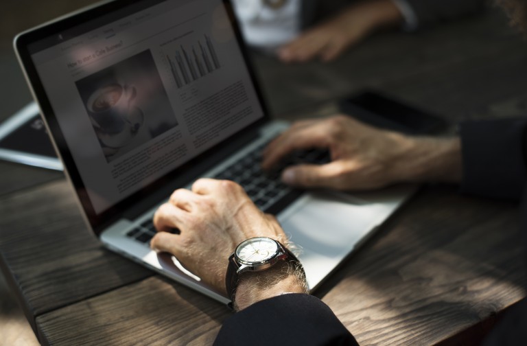 Empreendedor conferindo em um site de notícias aberto no seu laptop as novidades sobre a nova lei do e-commerce