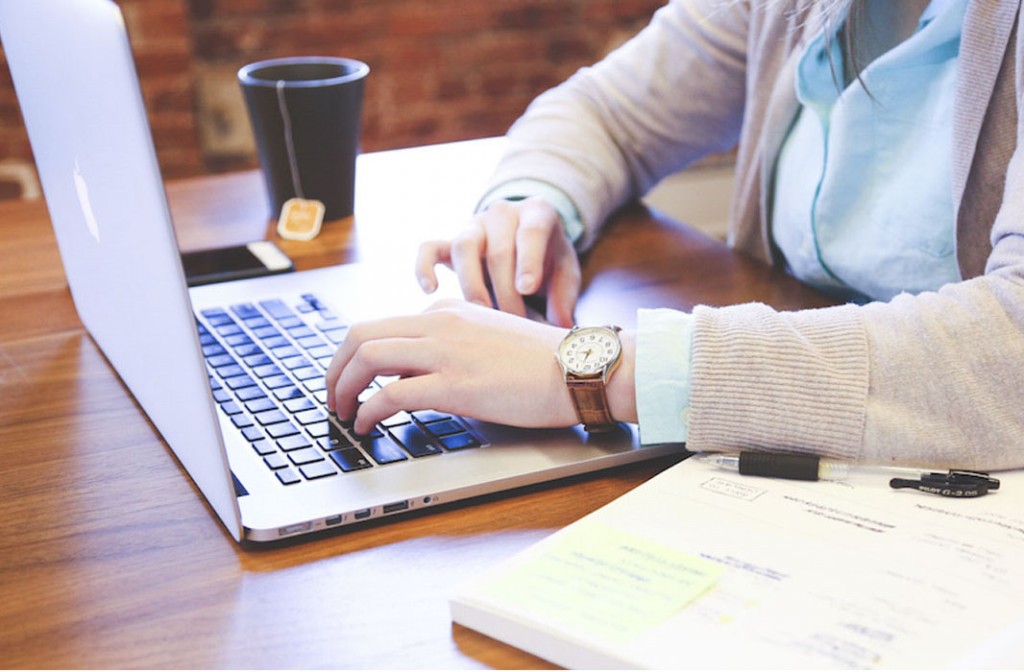 Dono de negócio tomando chá enquanto aprende no computador como economizar investindo em tecnologia