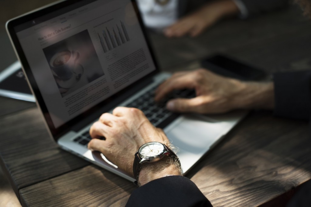 Empreendedor digitando em seu notebook, conferindo as informações sobre a nova lei de divulgação de preços no e-commerce