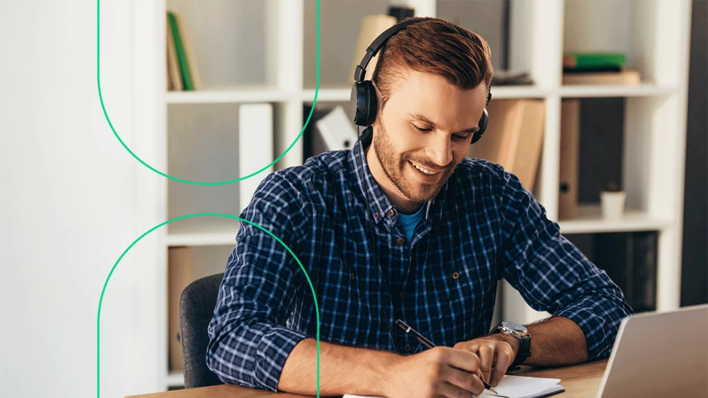 Empreendedor com fones de ouvido assitindo os webinars do Bling e fazendo anotações em sua agenda