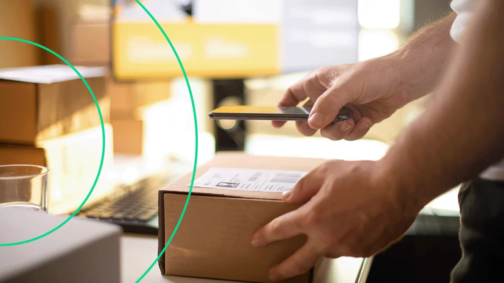 Pessoa escaneando código de encomenda com o celular para rastrear na Sislógica