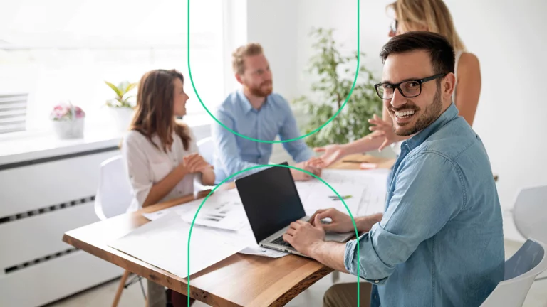 Homem sorrindo para a câmera enquanto conversa com outras pessoas, representando o especialista Magento ensinando tudo para os empresários