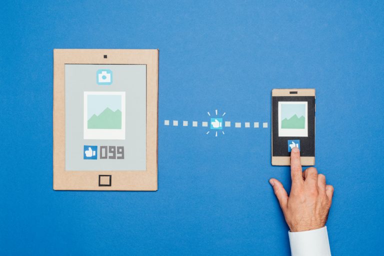 Representação de uma mão curtindo uma foto no Facebook Ads e então sendo conectado com o produto da empresa