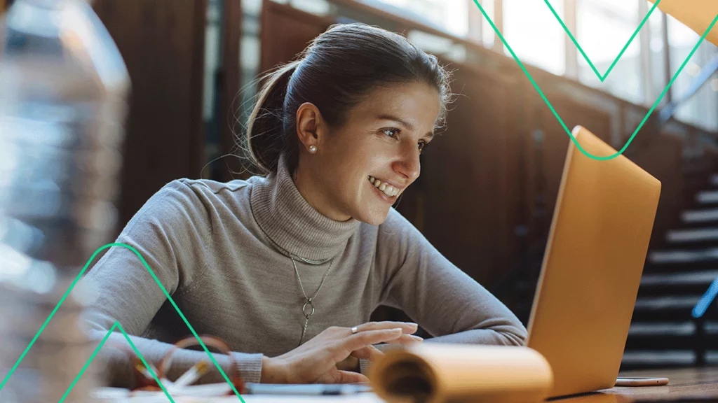 Mulher contente usando um notebook para entender como melhorar a personalidade da loja virtual dela