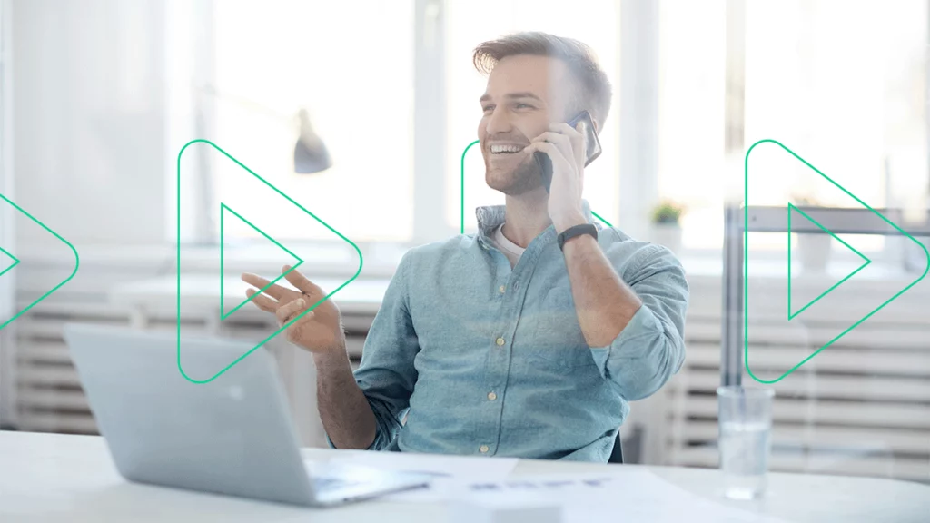 Homem em seu escritório, sorrindo e falando no celular, representando a tecnologia TotalVoice