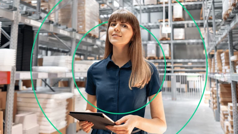 Empreendedora no depósito da empresa, segurando um tablet com o seu sistema de controle de estoque