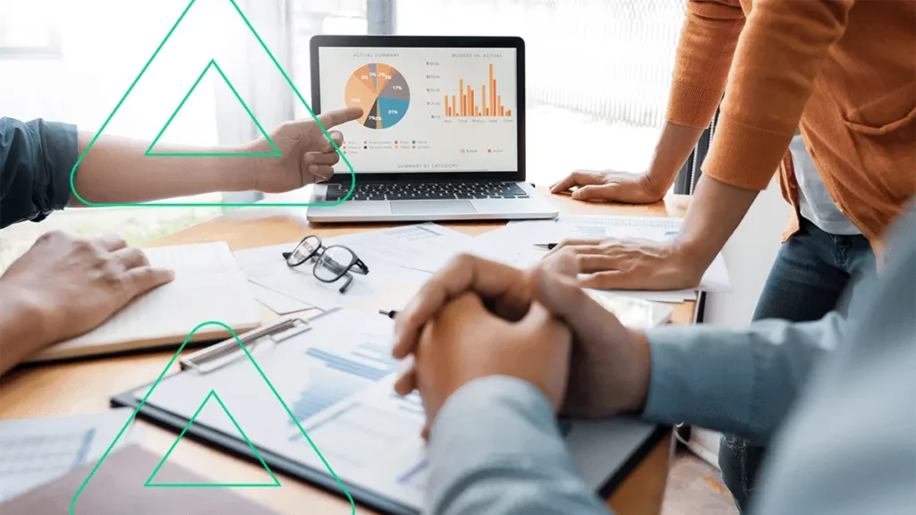 Pessoas olhando para gráficos em um notebook enquanto discutem sobre como converter mais com as campanhas do Google Ads