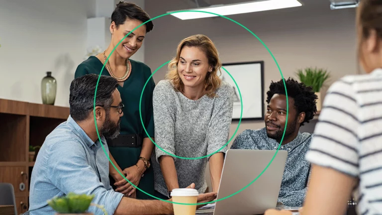 Grupo de empresários sorrindo ao olhar o relatório NuvemCommerce no computador