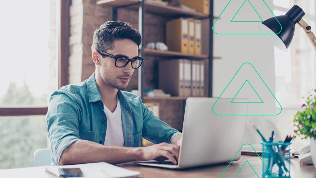 Empreendedor sorrindo enquanto lê no computador sobre as ações promocionais da B2W Marketplace