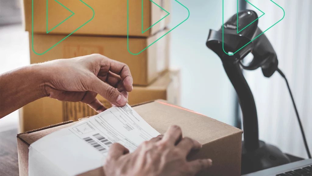 Pessoa colando uma etiqueta adesiva de transporte dos Correios em uma caixa