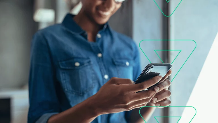 Empreendedora segurando seu celular na mão, conferindo o perfil da empresa no Instagram