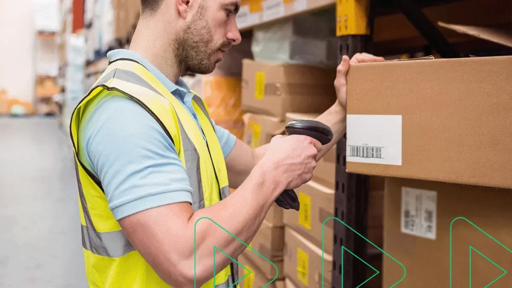 Funcionário escaneando encomendas no depósito de logística