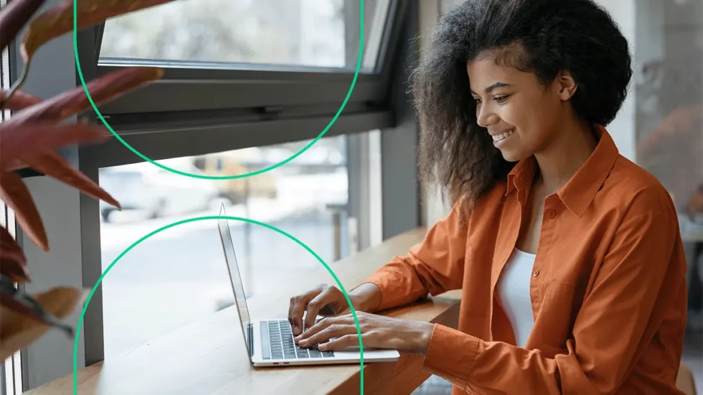 Empreendedora usando o computador e sorrindo, conseguindo emitir seus boletos no Bling com facilidade