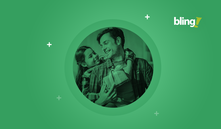 Foto de uma menina com um presente na mão abraçando seu pai no Dia dos Pais