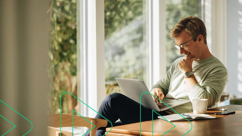 Empreendedor sorrindo ao conferir dicas de como seguir vendendo após a Black Friday em seu notebook