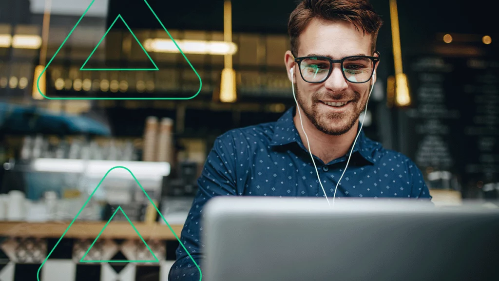 Empreendedor sorrindo com fones de ouvido enquanto assiste o webinar de como vender na Amazon