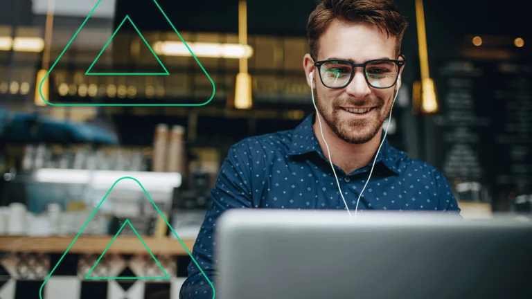 Empreendedor sorrindo com fones de ouvido enquanto assiste o webinar de como vender na Amazon