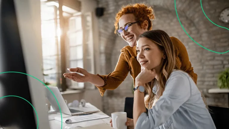 Empreendedora mostrando para outra mulher as promoções de cadastro em marketplaces dos parceiros Bling