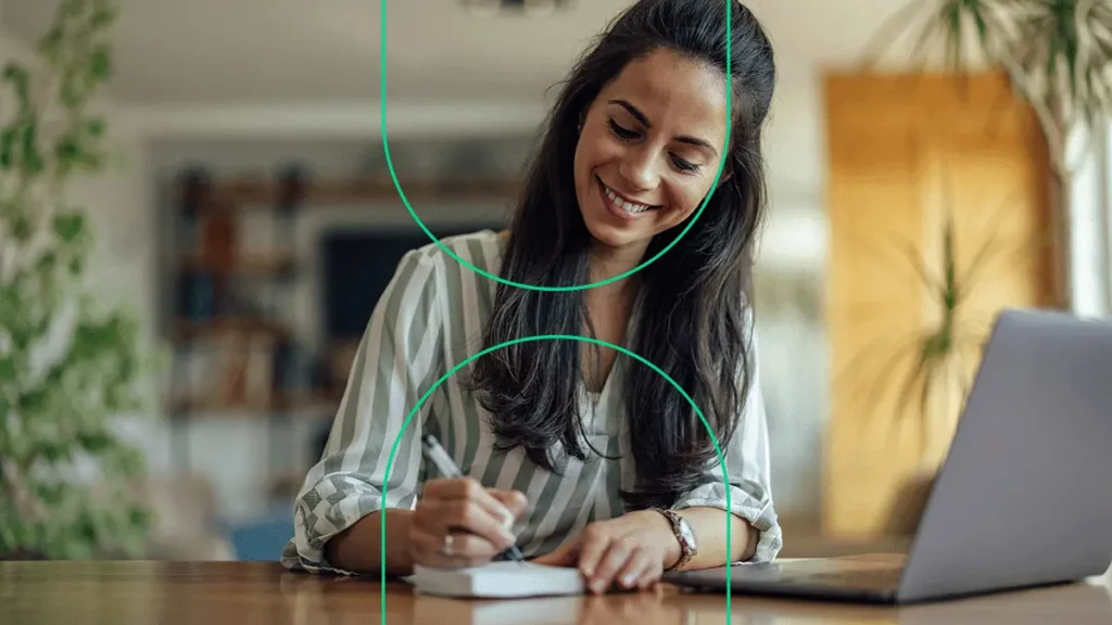 Mulher sorrindo enquanto faz anotações sobre os setores que mais crescerão no e-ecommerce