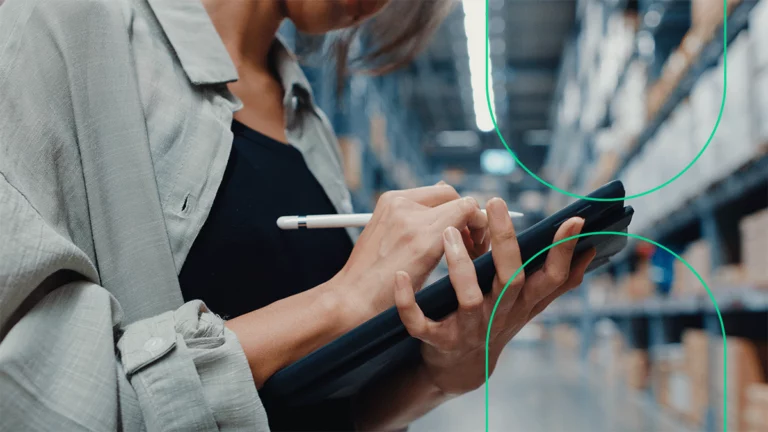 Empreendedora no depósito da empresa, fazendo o controle de estoque em um tablet