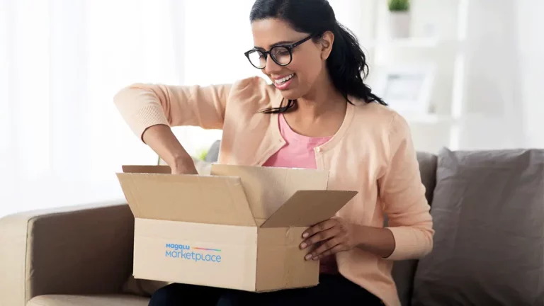 Mulher sorrindo ao abrir uma caixa com o logotipo do Magalu Marketplace