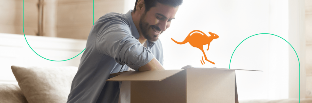 Homem feliz ao abrir sua encomenda recém chegada, com uma ilustração do logotipo da Kangu em cima da caixa