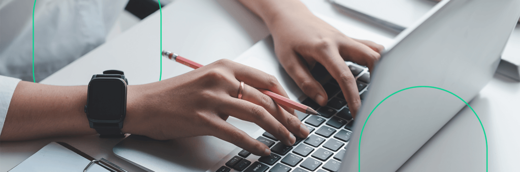 Close-up de mãos digitando em um notebook, preenchendo os novos campos customizados para clientes do Bling
