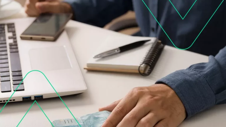 Empreendedor fazendo o cálculo do pró labore, com o computador, papel e caneta