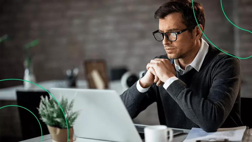 Empreendedor com expressão de concentração, lendo sobre o CNAE em um computador