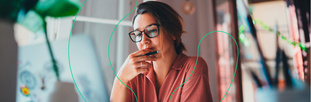 Mulher olhando para o computador de forma pensativa
